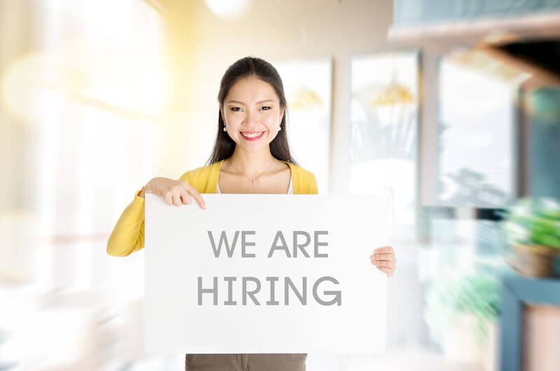 Lady holding we are hiring sign happy office employee